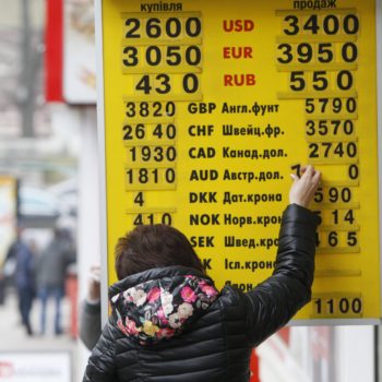 A woman changes an exchange rate on a display board at a currency exchange office in Kiev February 26, 2015. Ukraine's central bank unexpectedly banned most currency trading on Wednesday, only to abruptly reverse the decision overnight, causing havoc in the market for the plunging hryvnia. A separatist war in the east of the country has made it difficult to stabilise an economy on the verge of bankruptcy, and the hryvnia currency has already lost more than half its value so far this year after halving during all of 2014. REUTERS/Valentyn Ogirenko (UKRAINE - Tags: BUSINESS)