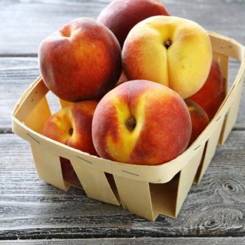 ripe peaches in wooden box, food closeup