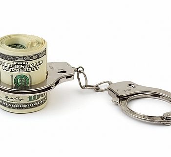 Money and manacles isolated on white background